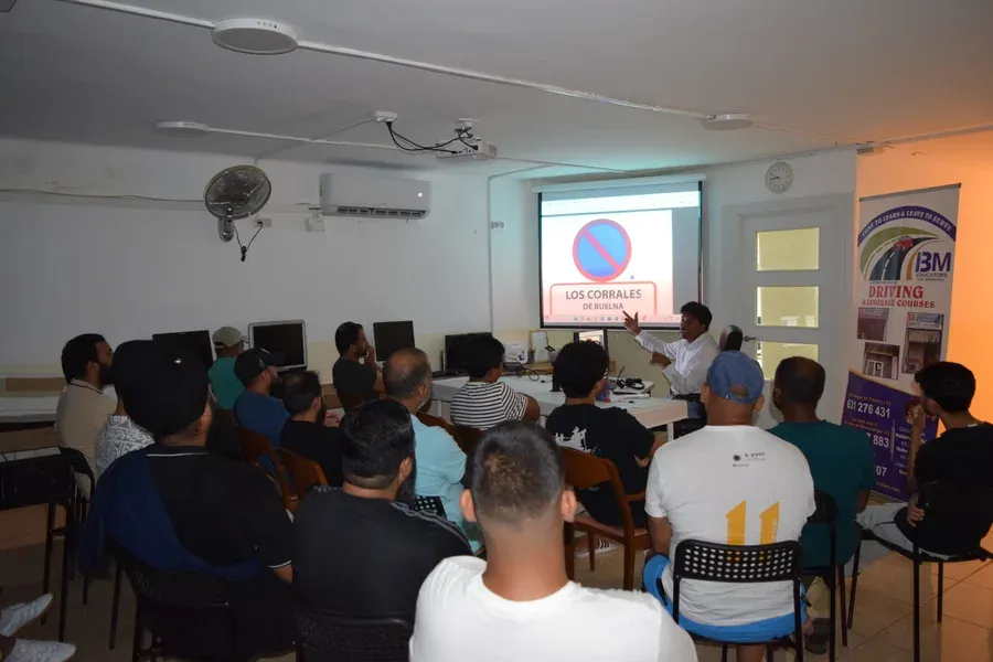 A theory class working through driving test questions together at a BM Autoescuela centre.